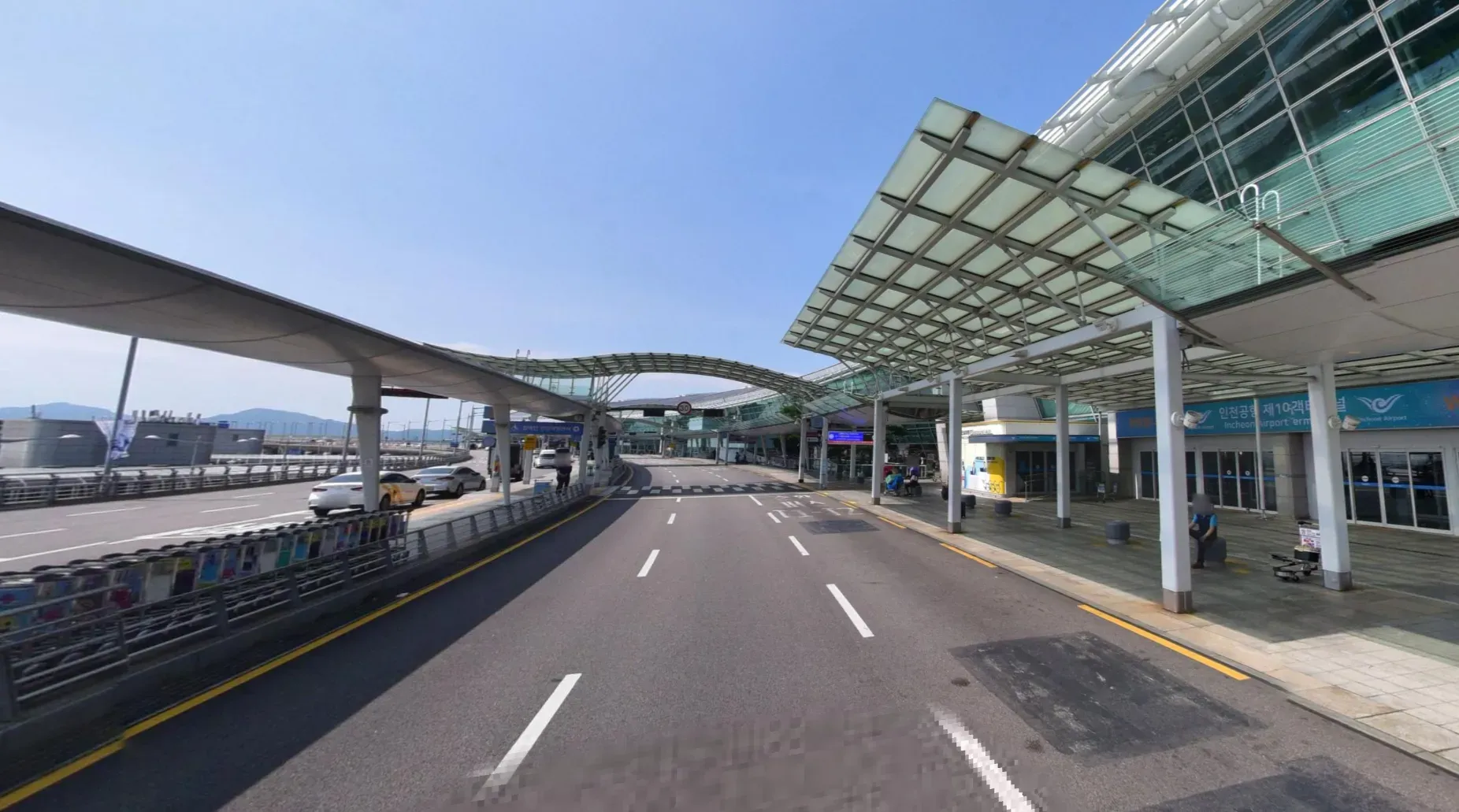 3층 출국장 내부에서 밖으로 나가는 문과 하차하는 버스들