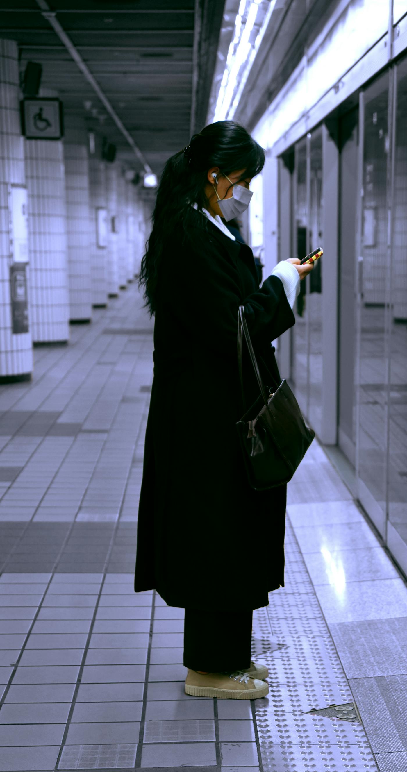 Traveler checking a phone on a Seoul subway platform