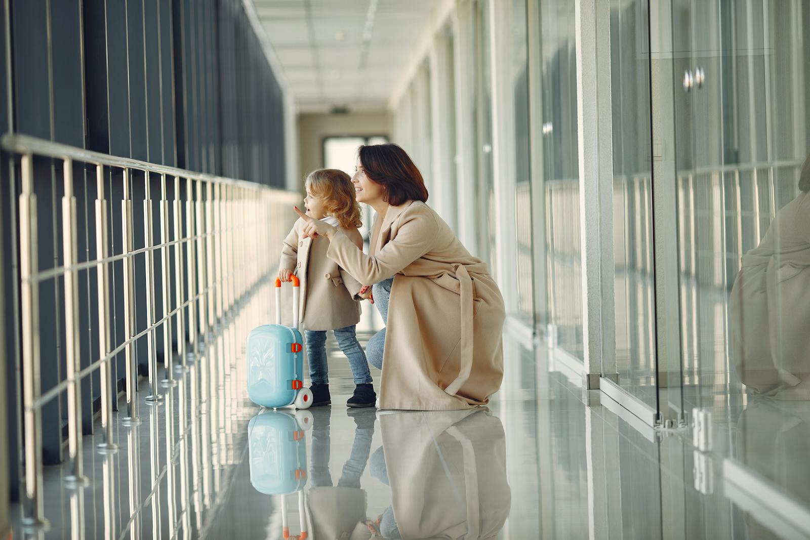 Parent and child with a suitcase in an airport corridor