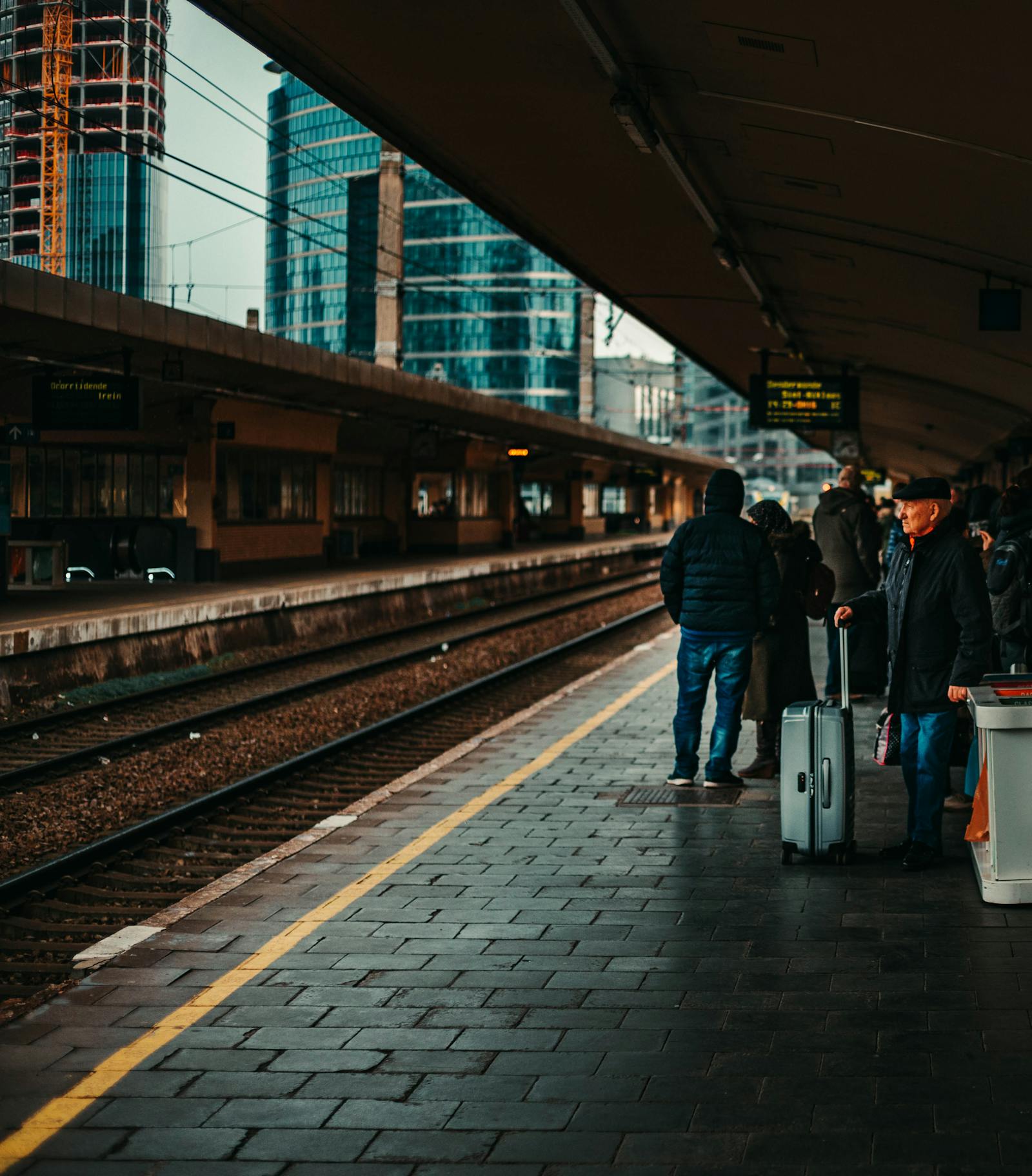 Traveler with a suitcase waiting on a train platform